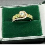 Ladies 10ct yellow gold ring set with a large round cut pale green topaz off set by green tourmaline