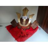 Oriental samurai warrior ornamental small display helmet and cushion.