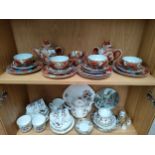 2 Shelves of tea wares to include oriental dragon pattern tea service, showing Geisha head sculpt to