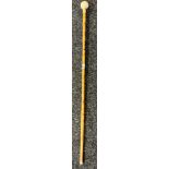 Bamboo walking cane fitted with a hidden blade. Resin sphere handle engraved with sun and star