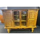 Large Light Oak Dutch display cabinet with shield crests and glass panels, supported on a pedestal