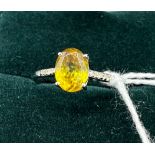 10ct white gold ladies ring set with an oval cut yellow stone off set by diamond shoulders. [Ring