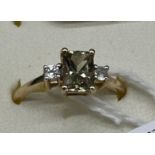 10ct yellow gold ladies ring set with a emerald cut pale green topaz stone off set by white spinel