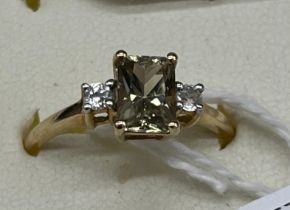 10ct yellow gold ladies ring set with a emerald cut pale green topaz stone off set by white spinel