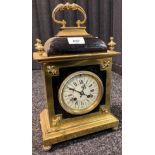 Antique 19th century heavy gilt brass and black leather mantel clock. Roman numerals on white enamel
