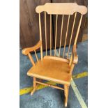 Lightwood rocking chair with arm rests.