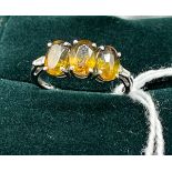 10ct white gold ladies ring set with three yellow/ amber coloured stones off set by diamond
