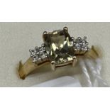 10ct yellow gold ladies ring set with a pale green topaz stone off set by white spinel stone