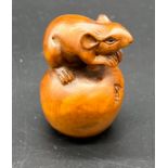 Japanese hand carved boxwood netsuke sculpture of a mouse sat upon an apple. Signed.