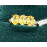 10ct yellow gold ladies ring set with three yellow stones off set by diamond shoulders. [Ring size