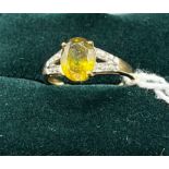 10ct yellow gold ladies ring set with a yellow stone off set by diamond shoulders. [Ring size N] [
