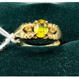 9ct yellow gold ladies ring set with a green stone off set by single smokey quartz shoulders. [