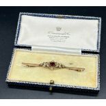 Antique 9ct yellow gold Edwardian bar brooch set with a single garnet centre stone off set by seed