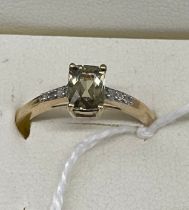 10ct yellow gold ladies ring set with a cushion cut pale green spine off set by diamond