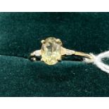 10ct yellow gold ladies ring set with a pale green topaz off set by diamond shoulders. [Ring size P]