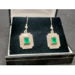 A Pair of silver earrings set with Emerald stones.