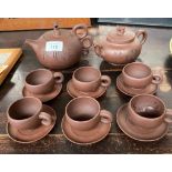 A Chinese Yixing pottery sake tea pot, cups and saucers. Stamped to the base.