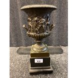 Antique bronze urn sat upon a slate base. Designed with Greek figures. [31.5cm high]