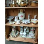 Two shelves of porcelain ware to include Art Nouveau inspired flower vases, candle sticks and