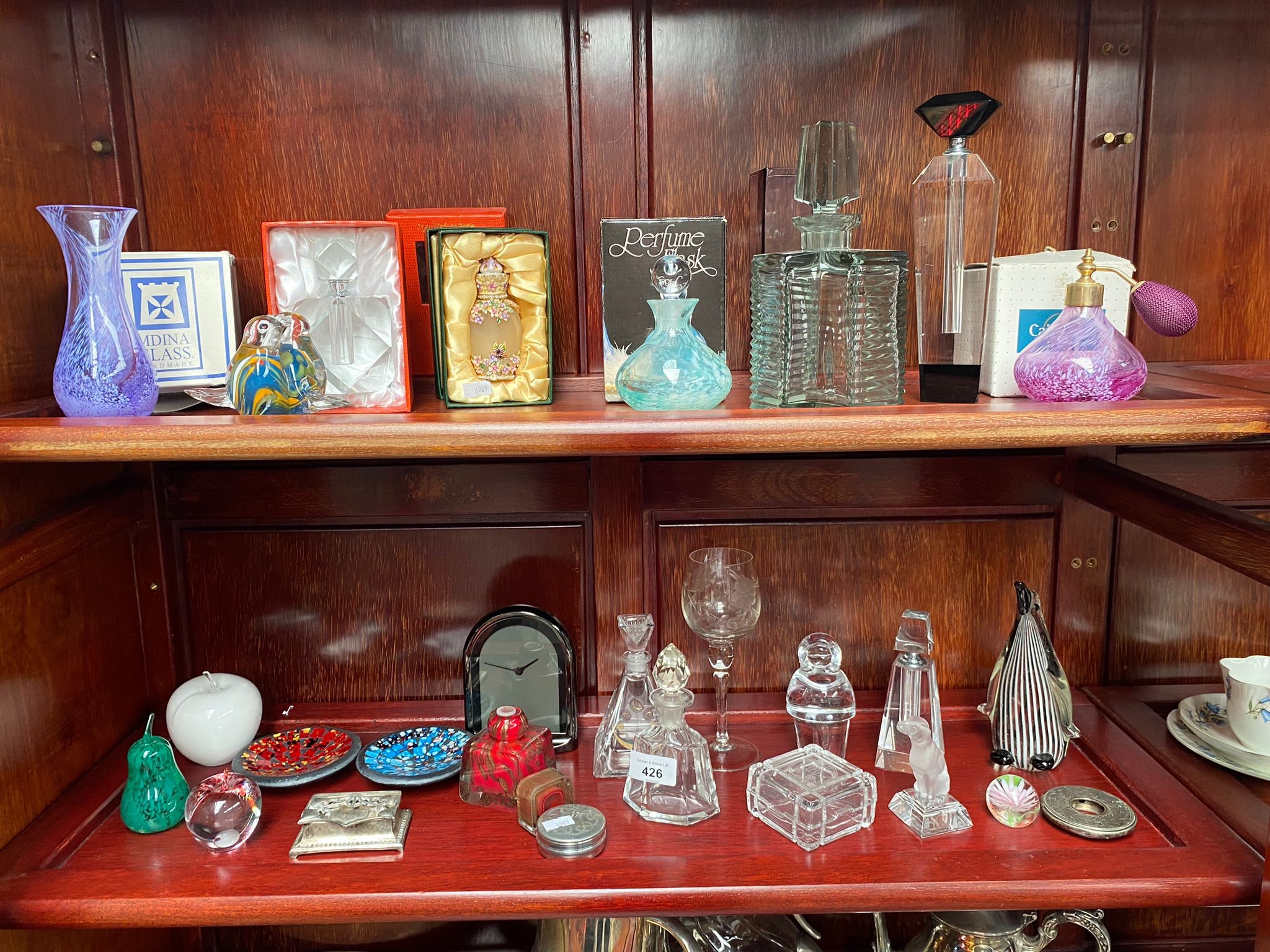 Two shelves of art glass and crystal perfume bottles and other items to include cut glass art deco