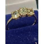 10ct yellow gold ladies ring set with three green topaz stones. [Ring size P] [1.64Grams]