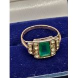 Art Deco 9ct gold ring set with a green cut stone off set by white stone shoulders. [All possibly
