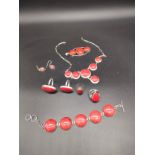 A Collection of silver jewellery fitted with red stones. Includes bracelet, four rings, large