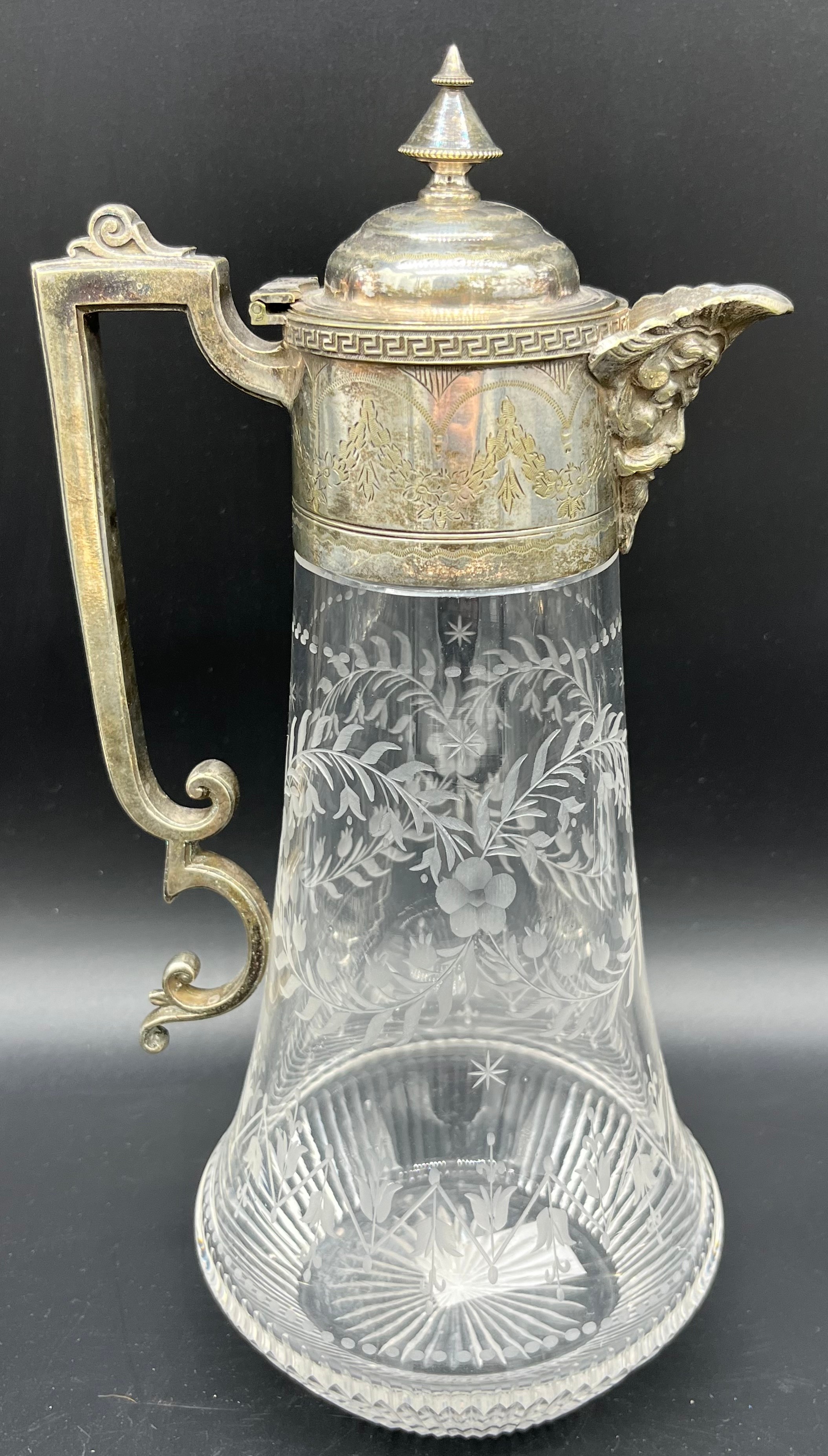 Antique claret jug designed with an ornate silver plate handle and spout, body is crystal with