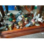 Shelf of bird ornaments to include osprey, Beswick parrot etc