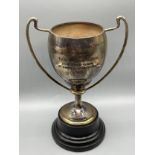 Birmingham silver two handle trophy with turned wooden stand. [Trophy stands 17cm high] [Weighs-