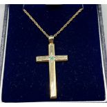 9ct yellow gold cross pendant fitted with a green stone, comes with a 9ct yellow gold necklace. [5.