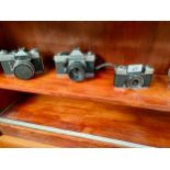 Shelf of vintage cameras includes pracktica etc
