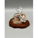 Antique Chinese hand carved clear stone rabbit sculpture. Sat upon a wooden base.