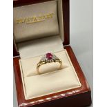 9ct yellow gold ladies ring set with a single ruby stone off set by diamond cluster. 0.25cts