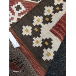 A Brown Woven Rug with kibak design.