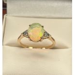 10CT Yellow gold ladies ring set with An Ethiopian opal stone off set by green Spinel Stone