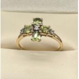 10ct yellow gold ladies ring set with four green quartz stones and three white spinel stones. [