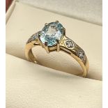 9ct yellow gold ladies ring set with a single blue spinel stone off set by diamond stones to each
