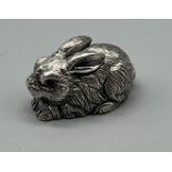 A Sterling silver sculpture of a rabbit set with ruby eyes. [3cm in length]