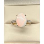 10ct yellow gold ladies ring set with a large opal stone off set by white topaz stone shoulders. [