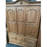 A Large pine triple wardrobe with fitted under drawers