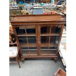 A 1930s china cabinet supported on queen Anne legs