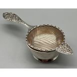 A Birmingham silver tea strainer and dish. Produced by S J Rose & Son and dated 1975.