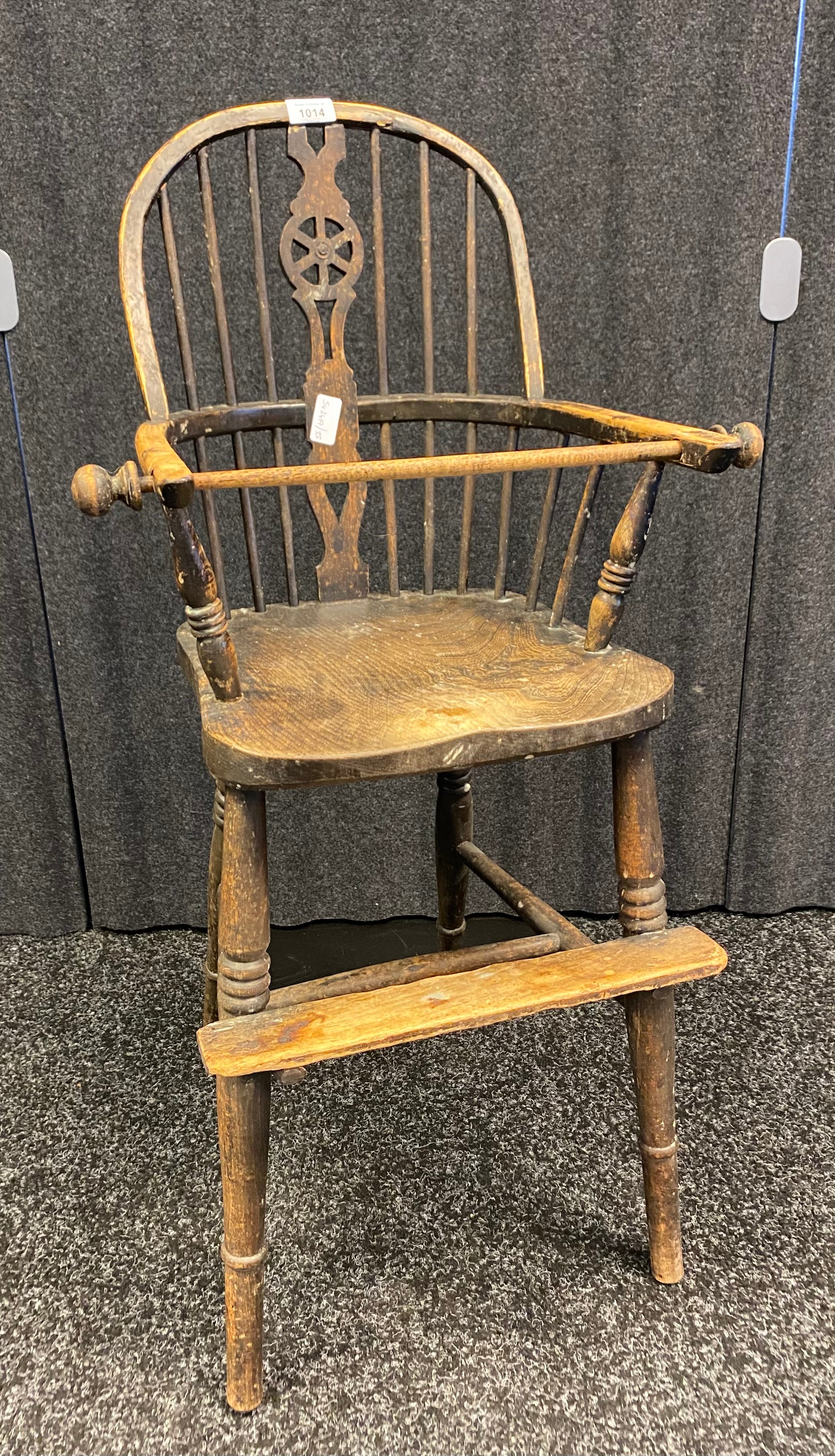 Antique elm Windsor style child's high chair, the shaped back with spindles and central carved splat