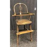 Antique elm Windsor style child's high chair, the shaped back with spindles and central carved splat