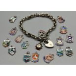 Silver charm bracelet together with silver and enamel souvenir shield fobs.