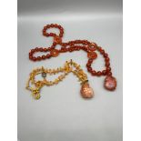 Two Chinese quartz necklaces, one polished round beads, the other with yellow shards, each with a