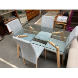 A contemporary dining room table consisting of 4 chairs in grey material