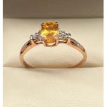 9ct rose gold ladies ring set with an orange stone and off set by clear stones. [Ring size R] [1.