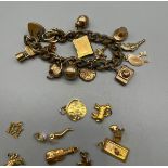 13 9ct gold charms attached to a gilt metal charm bracelet, together with 10 loose 9ct yellow gold